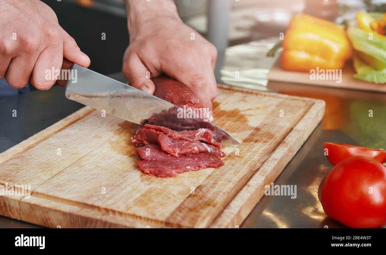 Kochen Sie Koteletts Fleisch für seine Unterschrift Gericht. Kochkonzept. Zugeschnittenes Bild Stockfoto