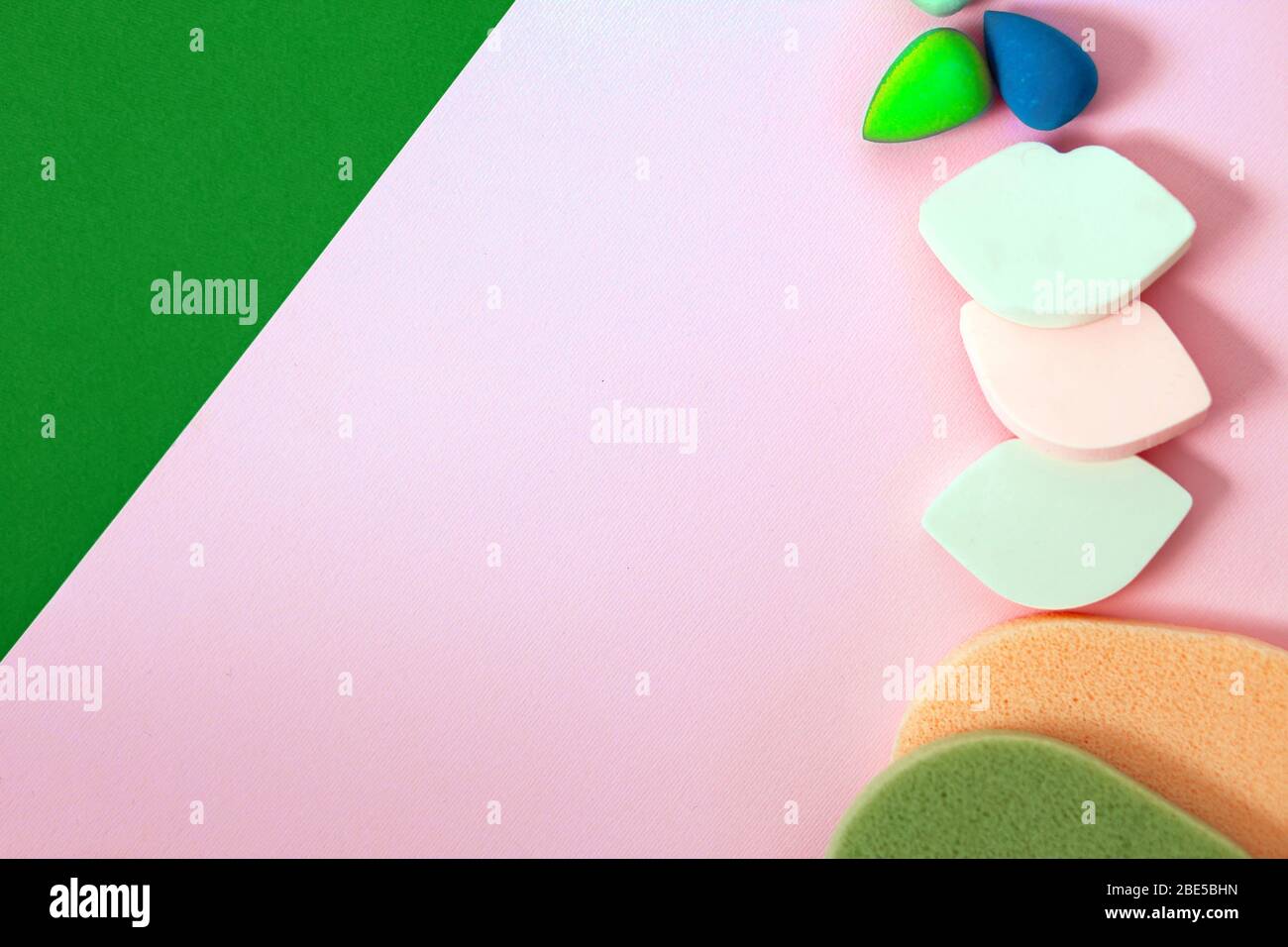 Kosmetik, Makeup, Schönheit, Mode, Jugend, Pflegekonzept. Nahaufnahme Draufsicht verschiedene und bunte Schminkschwappen auf pinkfarbenem Hintergrund mit Kopierbereich. Stockfoto