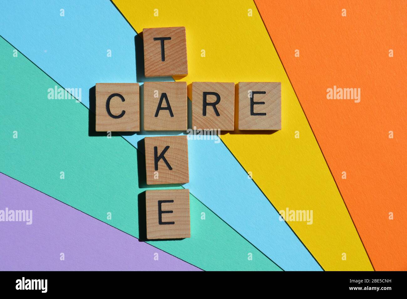 Take Care, Kreuzworträtsel in Holzbuchstaben Stockfoto