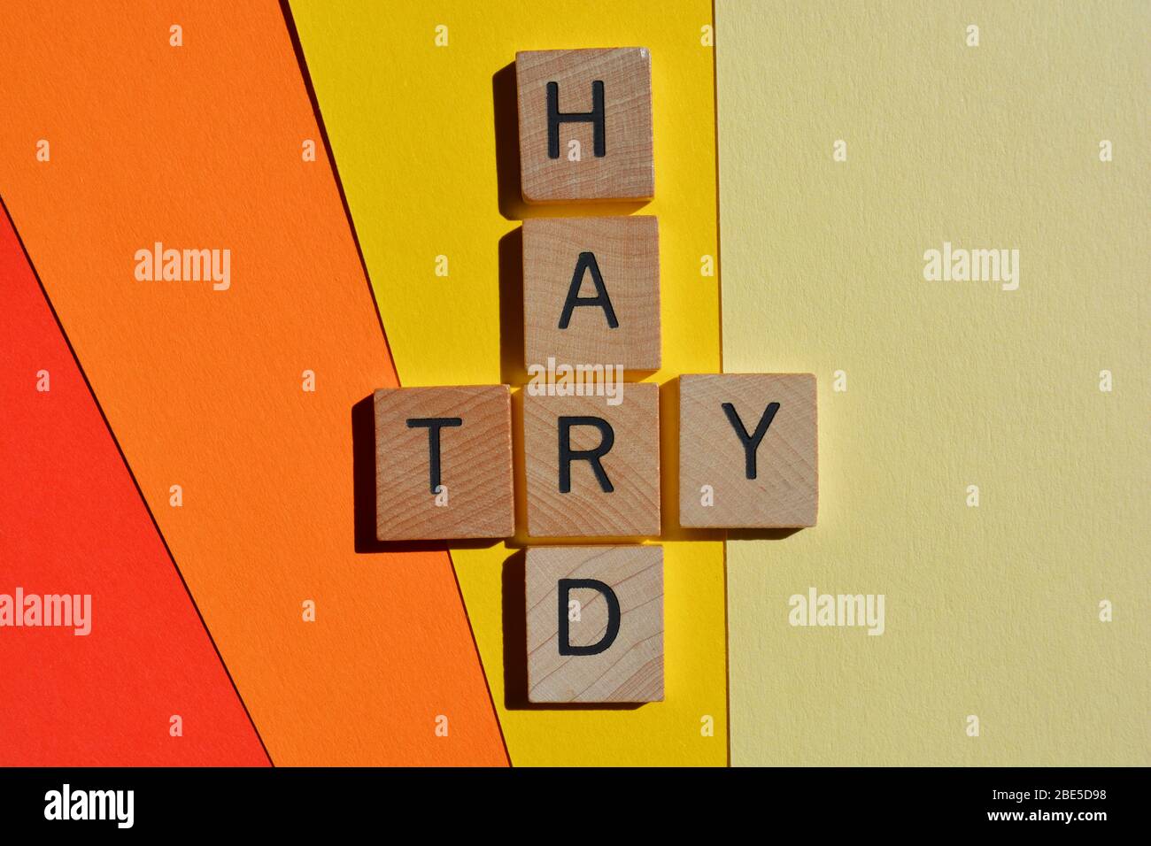 Versuchen Sie es hart, Wörter in 3d Holz Alphabet Buchstaben auf bunten Hintergrund Stockfoto