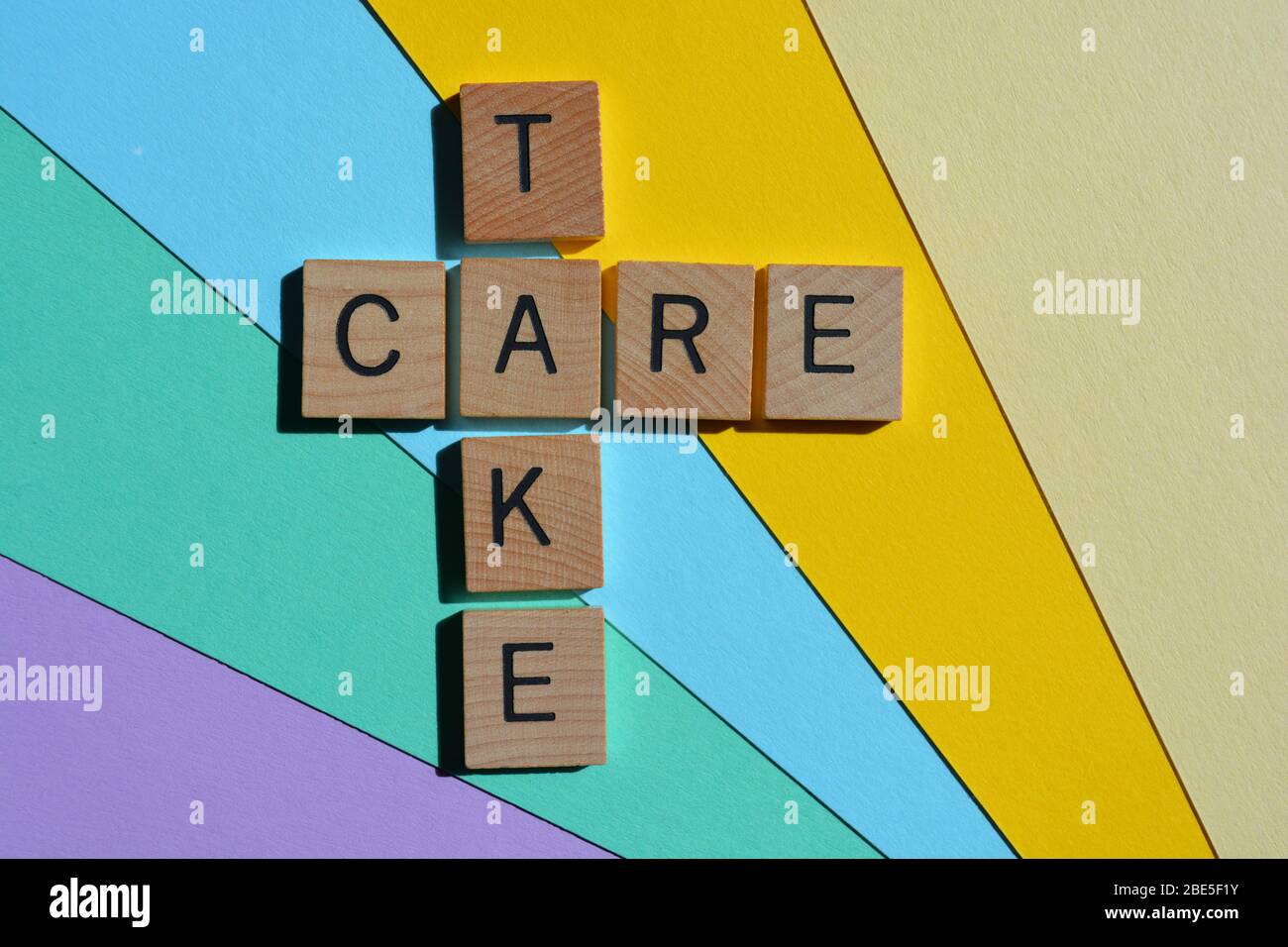 Take Care, Kreuzworträtsel in 3d-Holz-Alphabet Buchstaben Stockfoto