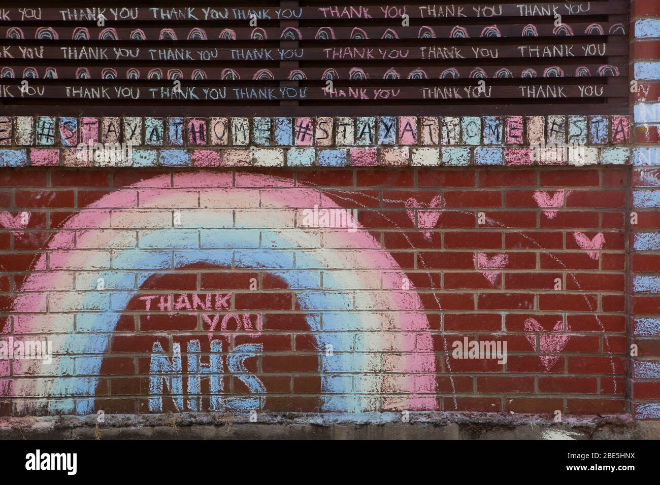 London, Großbritannien, 12. April 2020: An einem sonnigen Ostersonntag erschien an der Wand eines Hauses in Clapham ein Kreidegemälde mit Regenbogen, das sich bei NHS-Mitarbeitern und Schlüsselarbeitern bedankte und Regierungsanweisungen an #StayAtHome wiederholte. Anna Watson/Alamy Live News Stockfoto