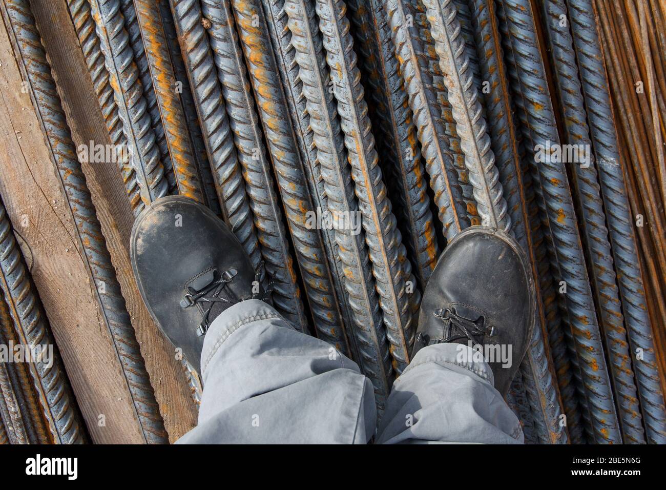 Arbeitsschuhe auf einem Baugrund. Arbeitsschuhe zum Ausgleich der Füße vor Beschädigungen. Arbeitsschutzkleidung auf einer Baustelle. Stockfoto