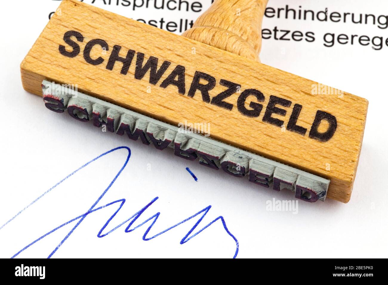Ein Stempel aus Holz liegt auf einem Dokument. Deutsche Aufschrift: Schwarzgeld Stockfoto