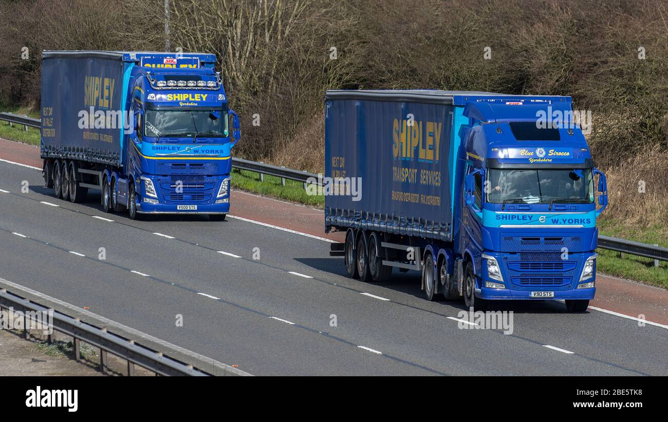Zwei Shipley's Transport Services; Yorkshire Speditions Delivery Trucks, blau Volvo LKW, Transport, LKW, Frachtführer, Fahrzeug, europäischen kommerziellen Transport, Industrie, M61 in Manchester, Großbritannien Stockfoto