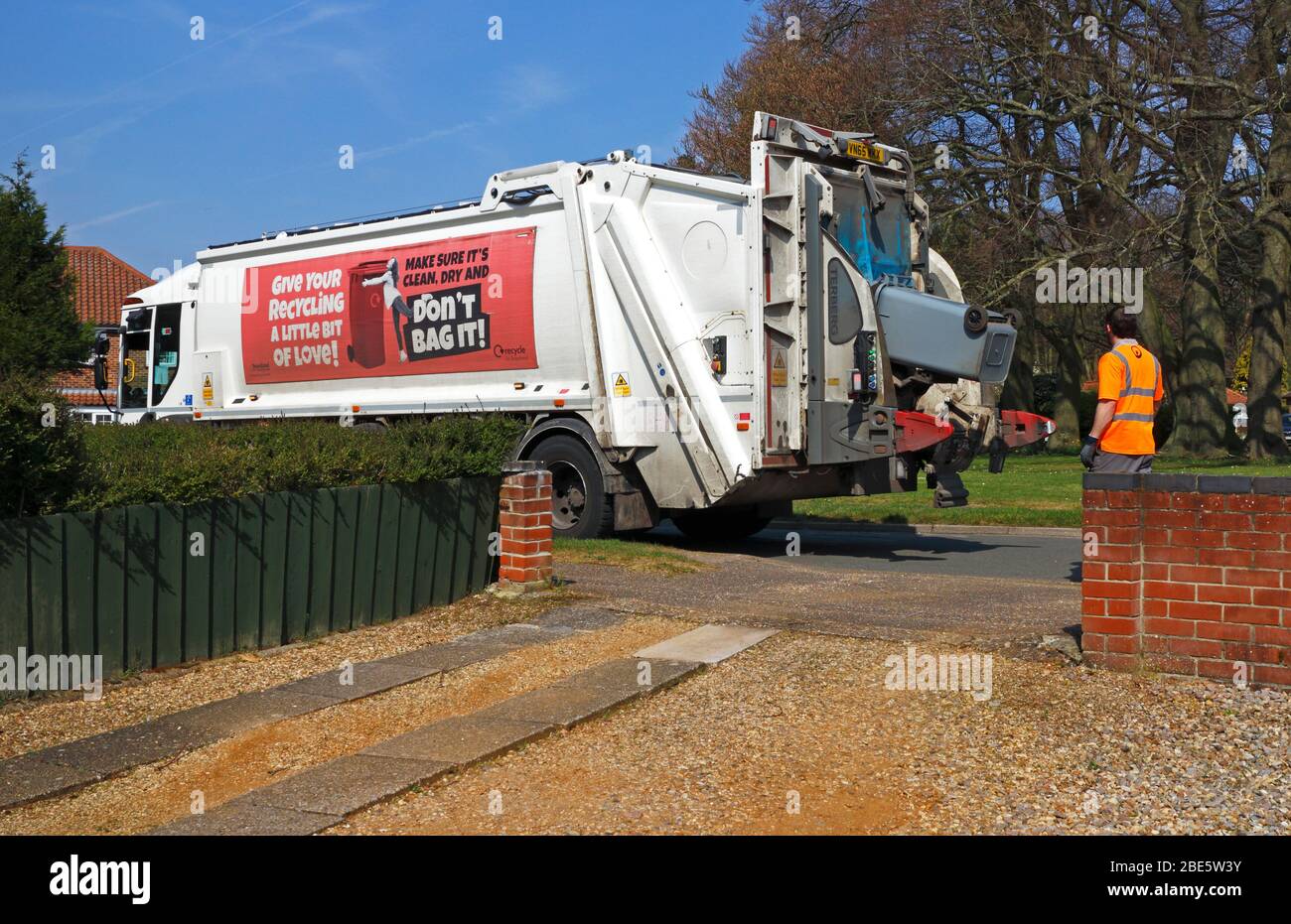 Ein Binman entleert einen Recyclingbehälter in einen Sammelwagen in einem Wohngebiet in Hellesdon, Norfolk, England, Großbritannien, Europa. Stockfoto