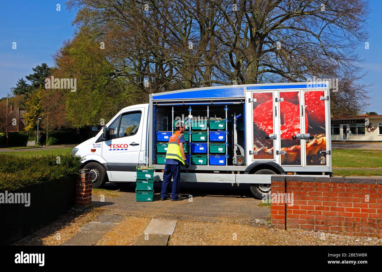 Ein Tesco Lieferwagen wird außerhalb eines Wohnhauses in Hellesdon, Norfolk, England, Großbritannien, Europa entladen. Stockfoto