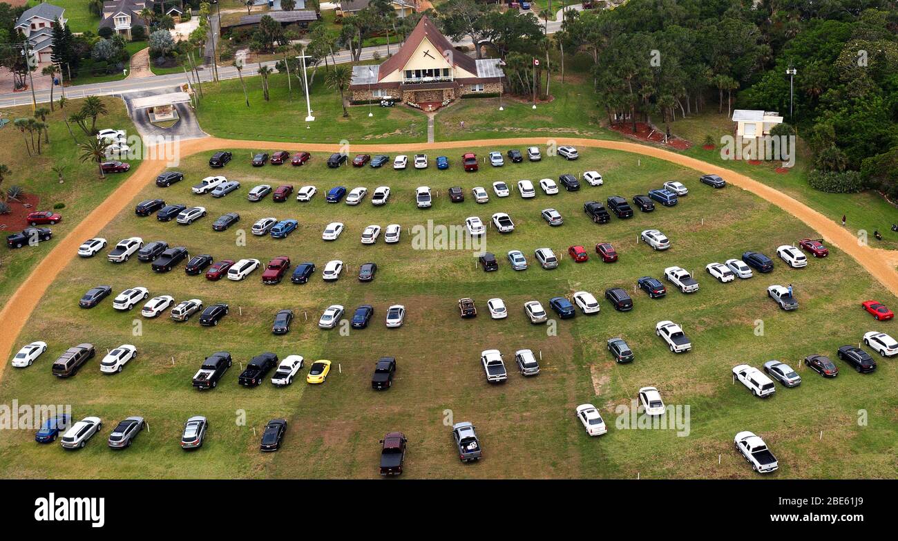 12. April 2020 - Daytona Beach Shores, Florida, USA - Menschen in Autos besuchen Ostersonntag Gottesdienste in der Daytona Beach Drive-in Christian Church als eine Möglichkeit, soziale Distanz während der Coronavirus-Pandemie am 12. April 2020 in Daytona Beach Shores, Florida zu üben. Floridas Aufenthalt-zu-Hause-Auftrag befreit religiöse Dienste, aber Gouverneur Ron DeSantis hat gegen die Teilnahme überfüllten religiösen Versammlungen geraten. (Paul Hennessy/Alamy) Stockfoto