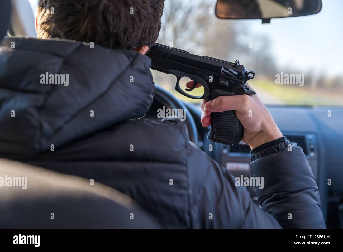 Ein Mann, der mit einer Waffe auf seinen eigenen Kopf zielt, um russisches Roulette zu spielen oder sich selbst zu töten Stockfoto