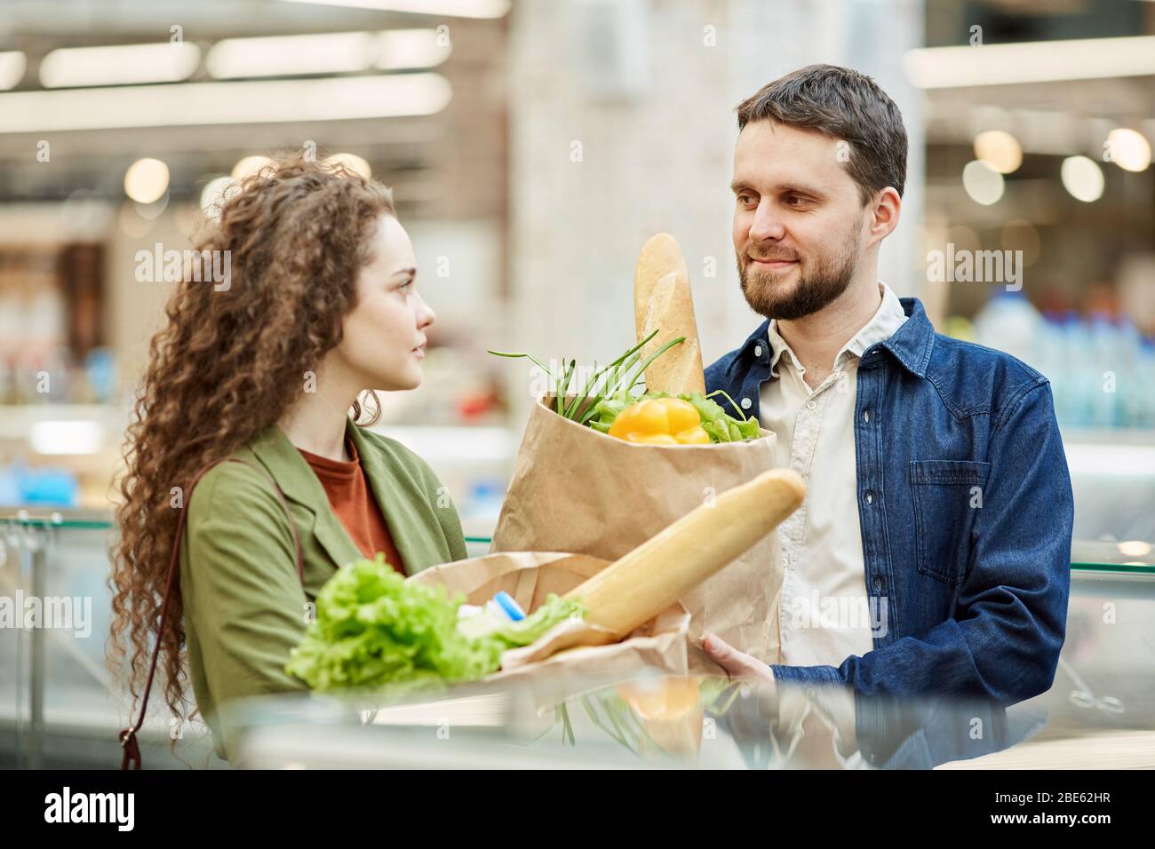 Taille up Porträt des modernen Paar hält Papiertüten mit Lebensmitteln beim Einkaufen im Supermarkt, kopieren Raum Stockfoto