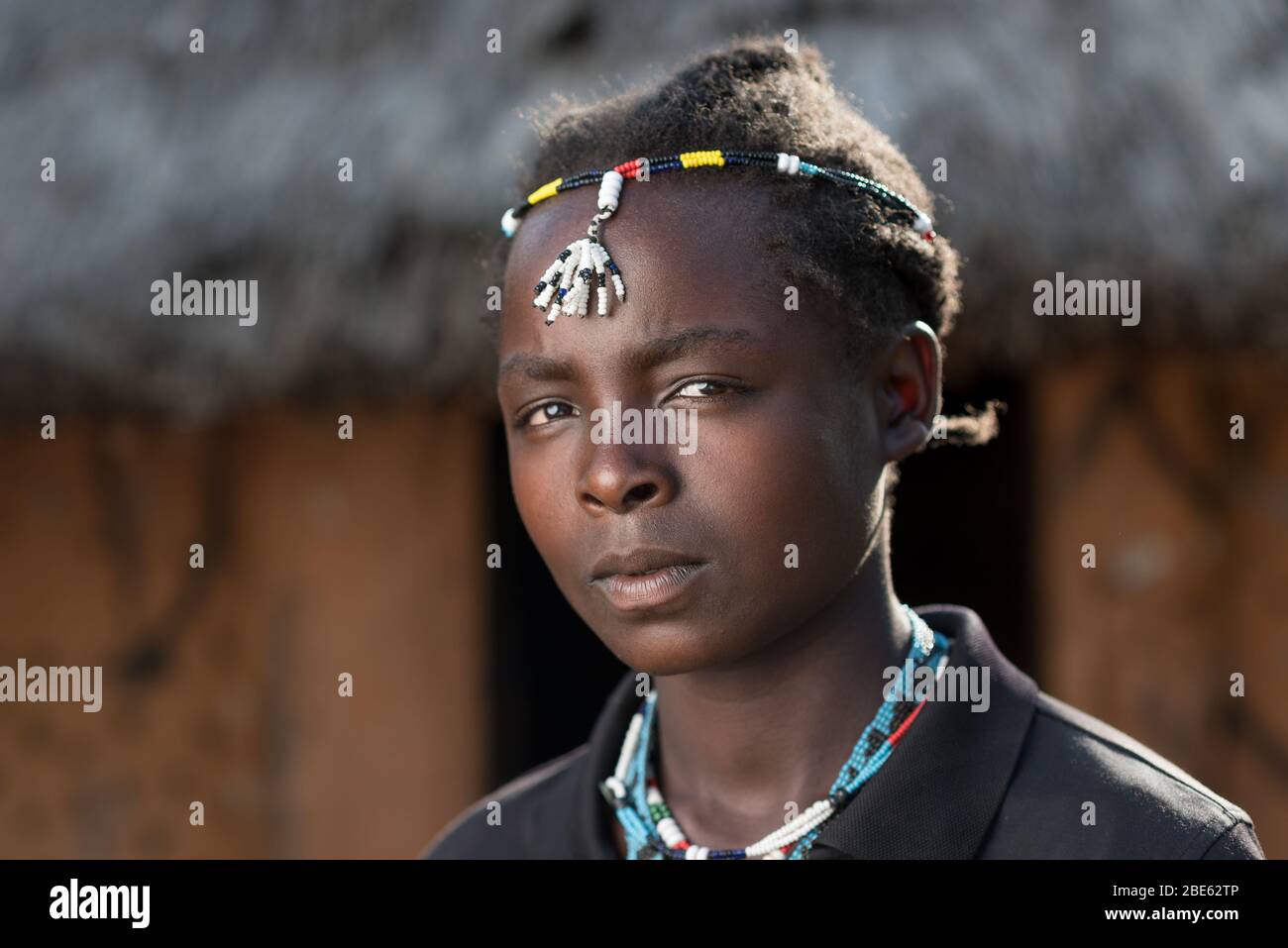 Junge Frau mit Perlen, die für ihre Ari-Ethnie oder ihren Stamm typisch sind, außerhalb ihres Schlammhauses, Jenka, Äthiopien. Stockfoto
