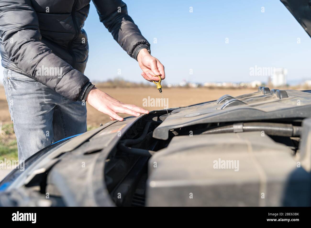 Der Fahrer überprüft den Ölstand im Fahrzeug auf unverschuldet befahrter Straße Stockfoto