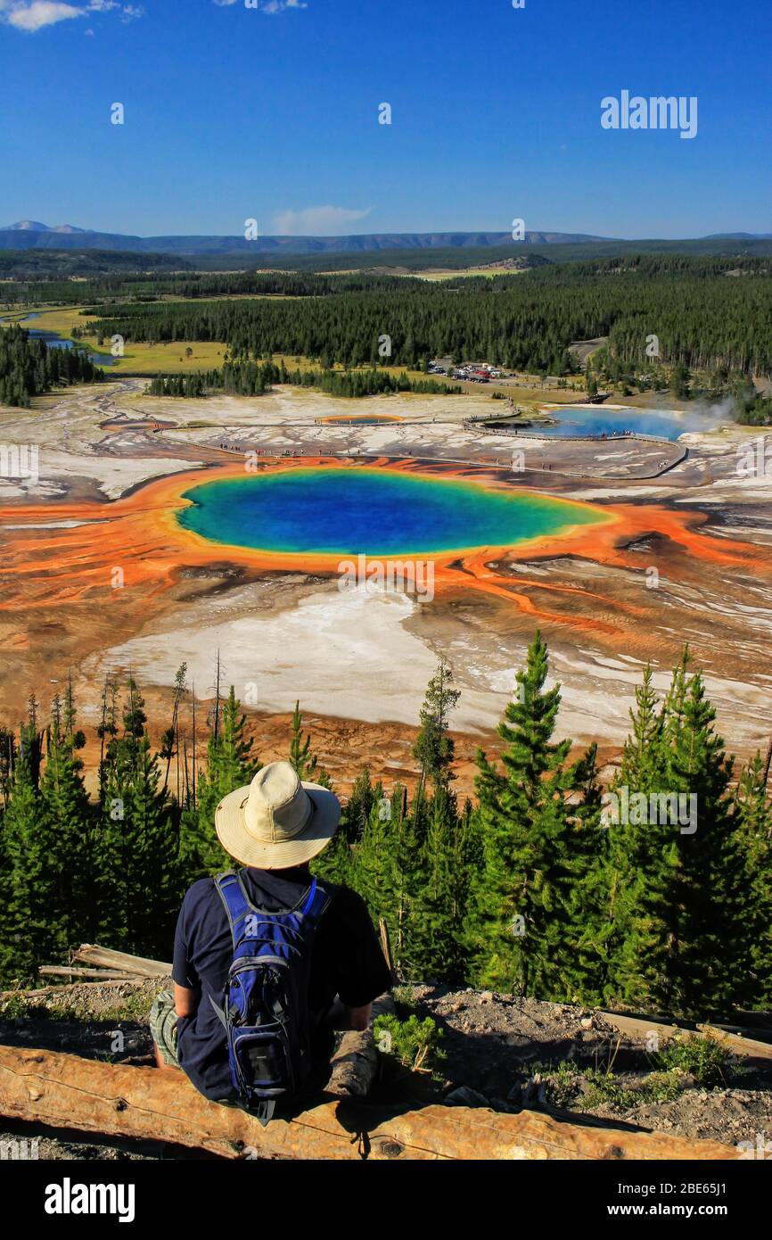 Touristen genießen die Aussicht auf Grand Prismatic Spring in Midway Geyser Basin, Yellowstone National Park, Wyoming, USA. Es ist die größte heiße Quelle in t Stockfoto