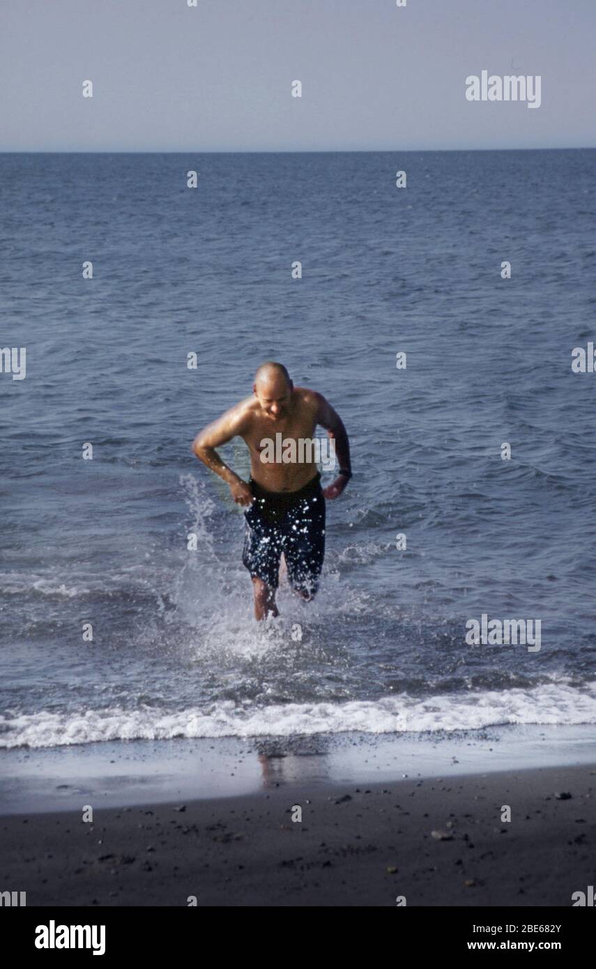 Ein Mann in Badehosen nimmt an einem Sommertag in Barrow, Alaska, USA, mutig ein Bad im Arktischen Ozean Stockfoto
