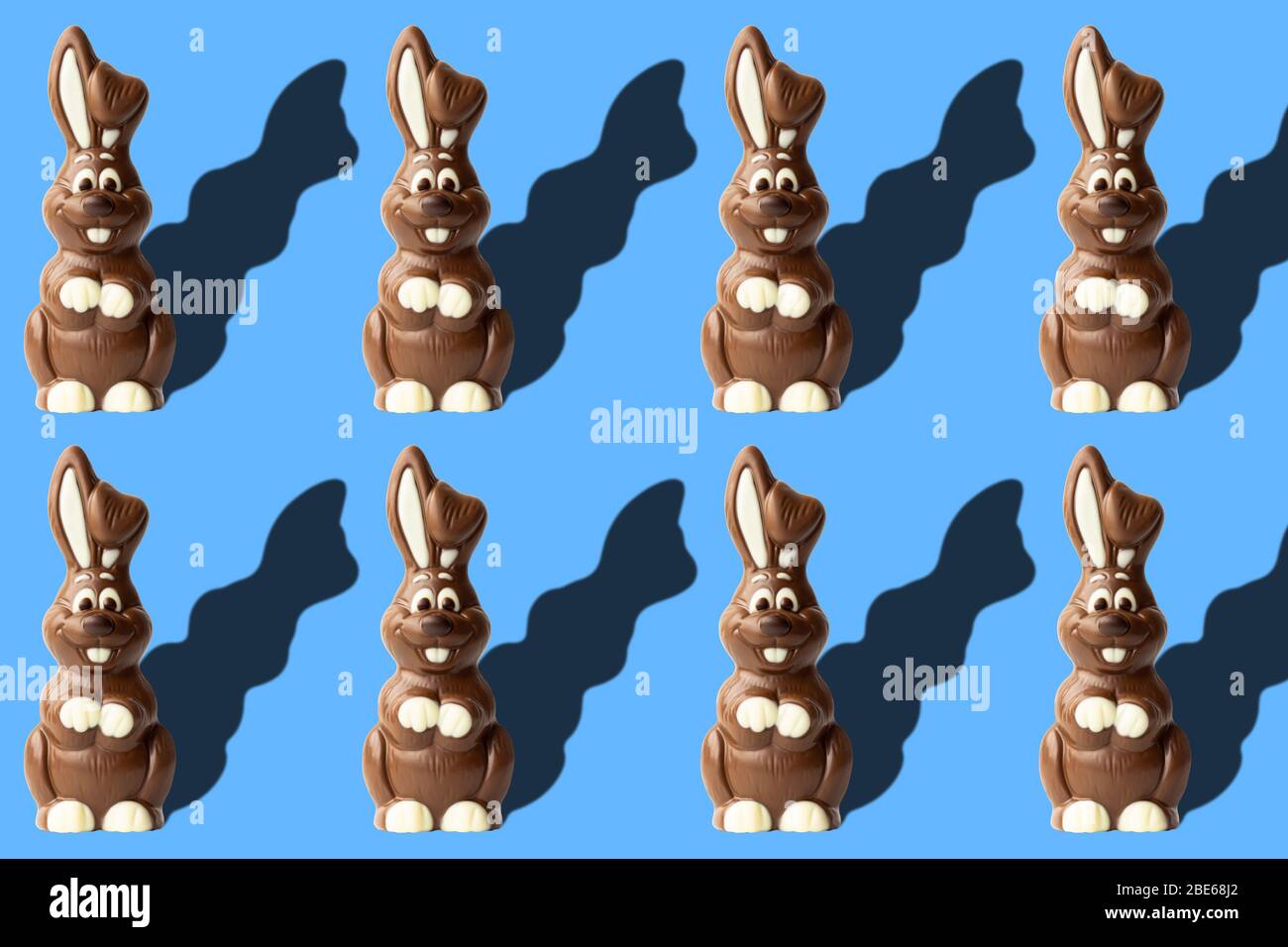Ostermuster mit Schokoladenkaninchen auf blauem Hintergrund. Ostern Konzept Bild mit Milch Schokolade Kaninchen Stockfoto