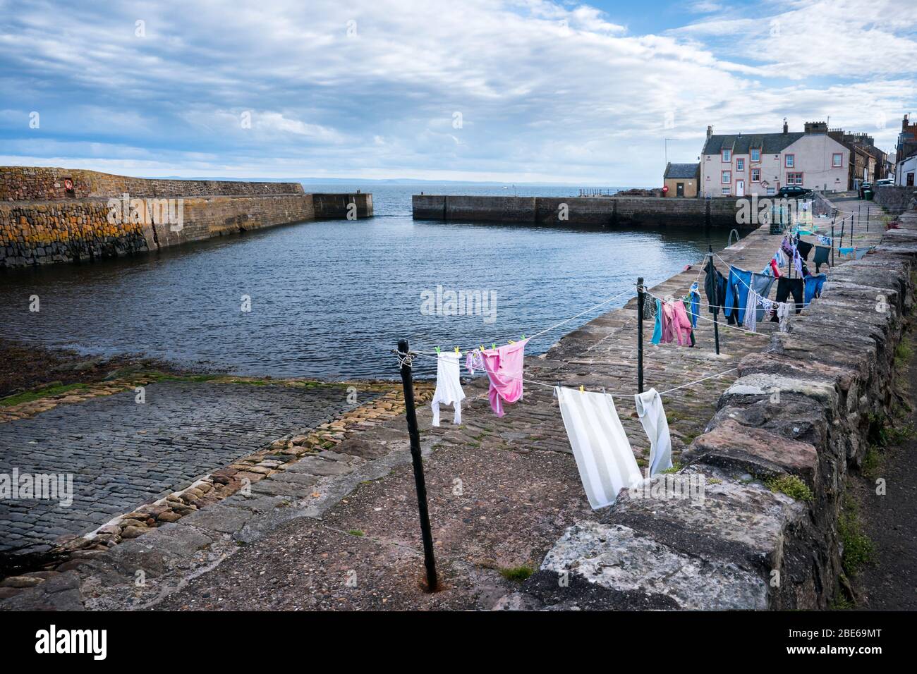 Wäscheleinen mit frischer Wäsche, die draußen am Pier des Fischerhafens, Crail, Kingdom of Fife, Schottland, Europa trocknet Stockfoto