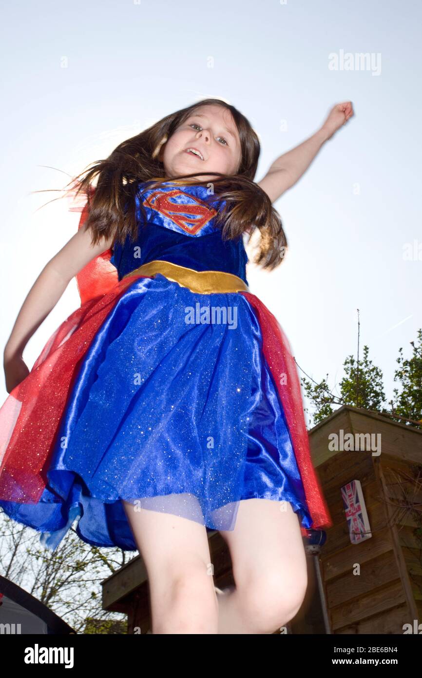 Junges Mädchen, das vorgibt, als Supermädchen zu fliegen, England Stockfoto