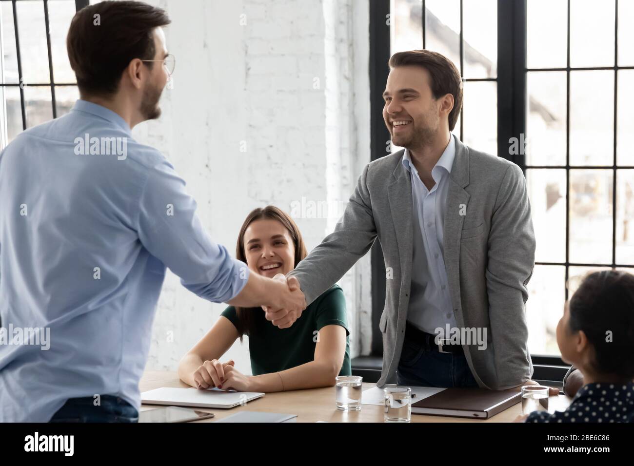 Glückliche männliche Kollegen Handshake Abschluss Deal im Büro Stockfoto