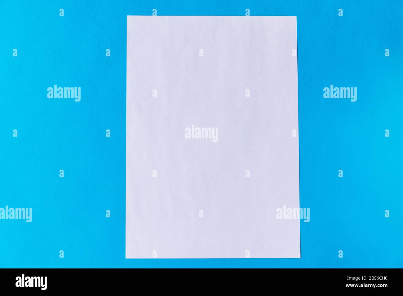 A4 weißes Blatt Papier auf blauem Hintergrund. Ideal für das Posten auf Instagram mit Platz für Ihren Text. Stockfoto