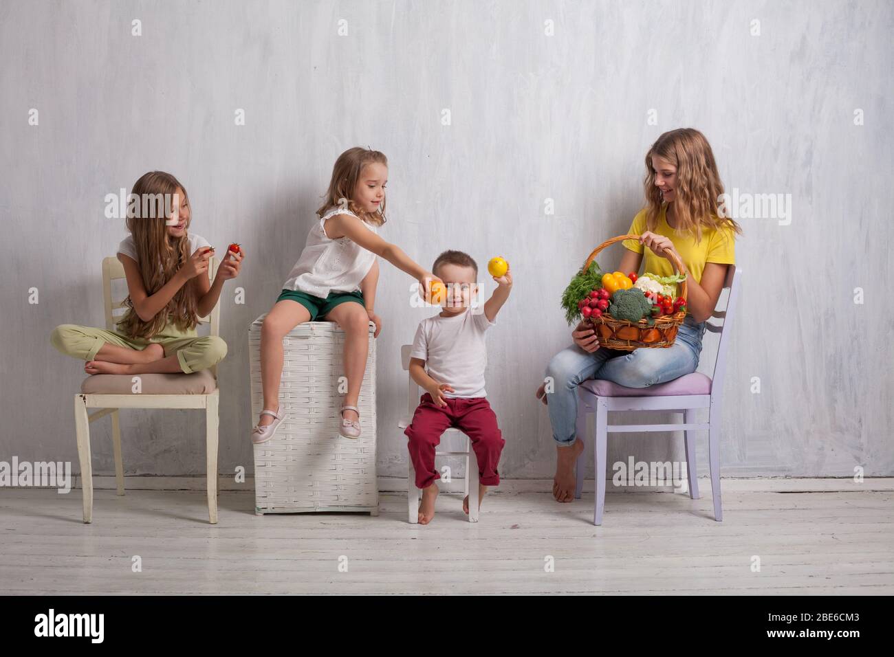 Jungen und drei Mädchen mit einem Korb von Gemüse und Obst Stockfoto