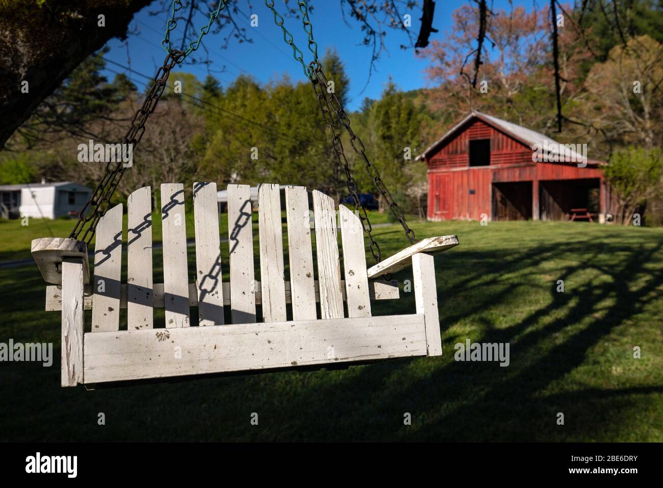 Porch Swing mit roter Scheune im Hintergrund - Penrose, North Carolina, USA Stockfoto