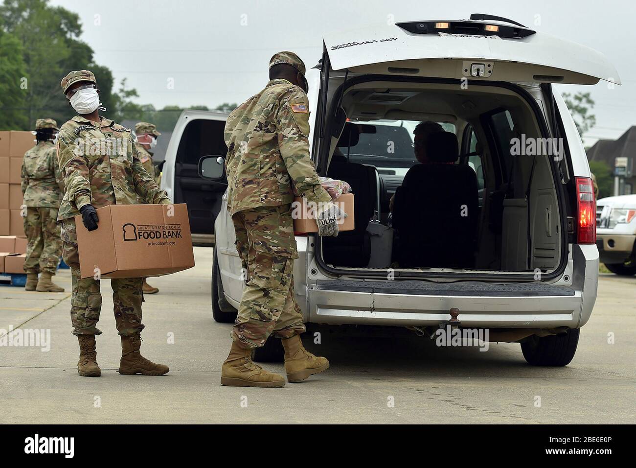 Louisiana National Guardsmen laden Kisten mit Nahrungsmittelhilfe Menschen, die unter den Auswirkungen der COVID-19, der Coronavirus-Pandemie, leiden, in der Great Baton Rouge Food Bank am 9. April 2020 in Walker, Louisiana. Stockfoto