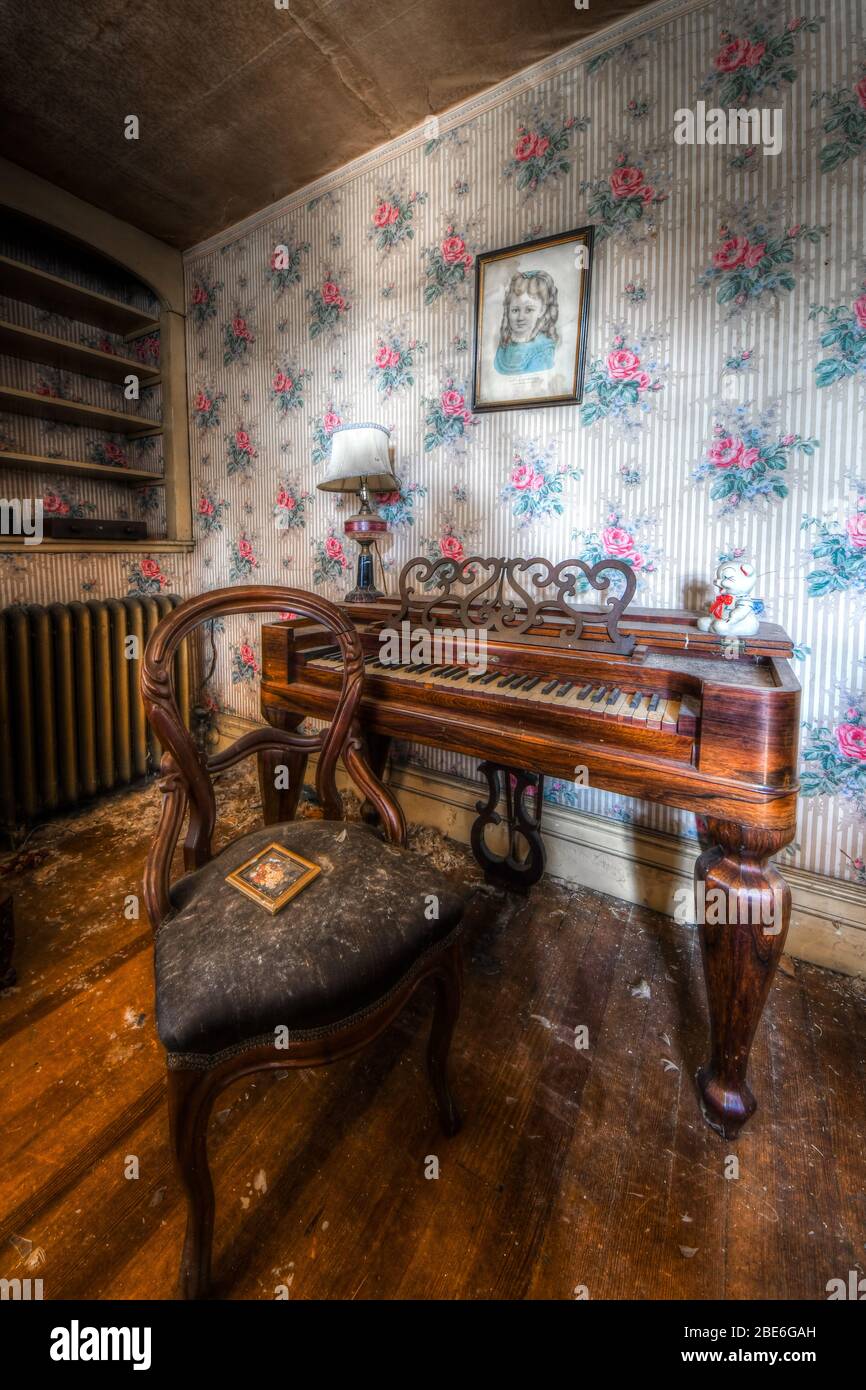 Piano-Musik-Zimmer in verlassenen Haus mit Tapeten und Antiquitäten Stockfoto