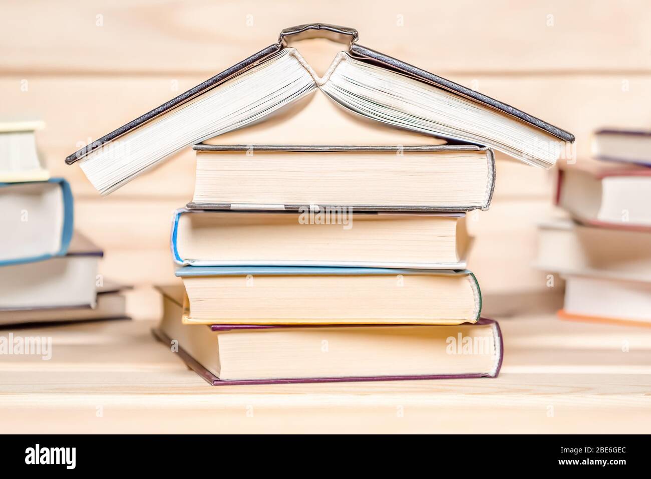 Druckausgaben. Verlag. Konzept für den Aufenthalt zu Hause. Haus mit Büchern auf Holzhintergrund gestapelt gemacht. Stapel von Büchern. Bildungskonzept. Stapel von Stockfoto