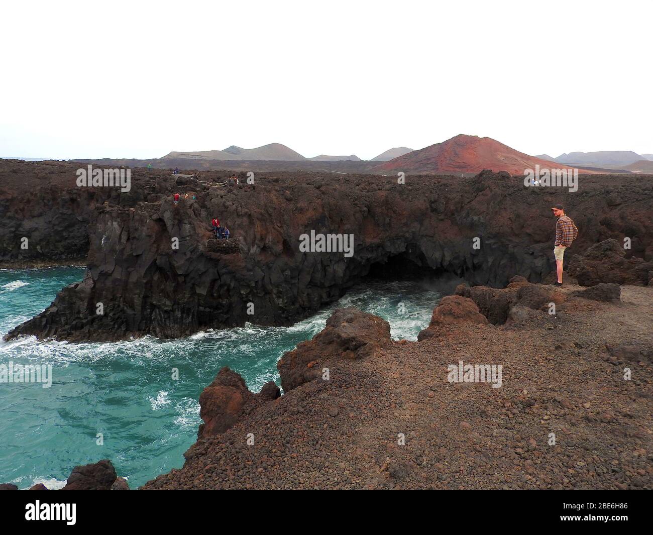 Ein Mann steht auf der Klippe bei Los Hervideros, Timanfaya, vulkanischer Nationalpark, Lanzarote, Kanarische Inseln, Spanien - Januar 2020. Stockfoto