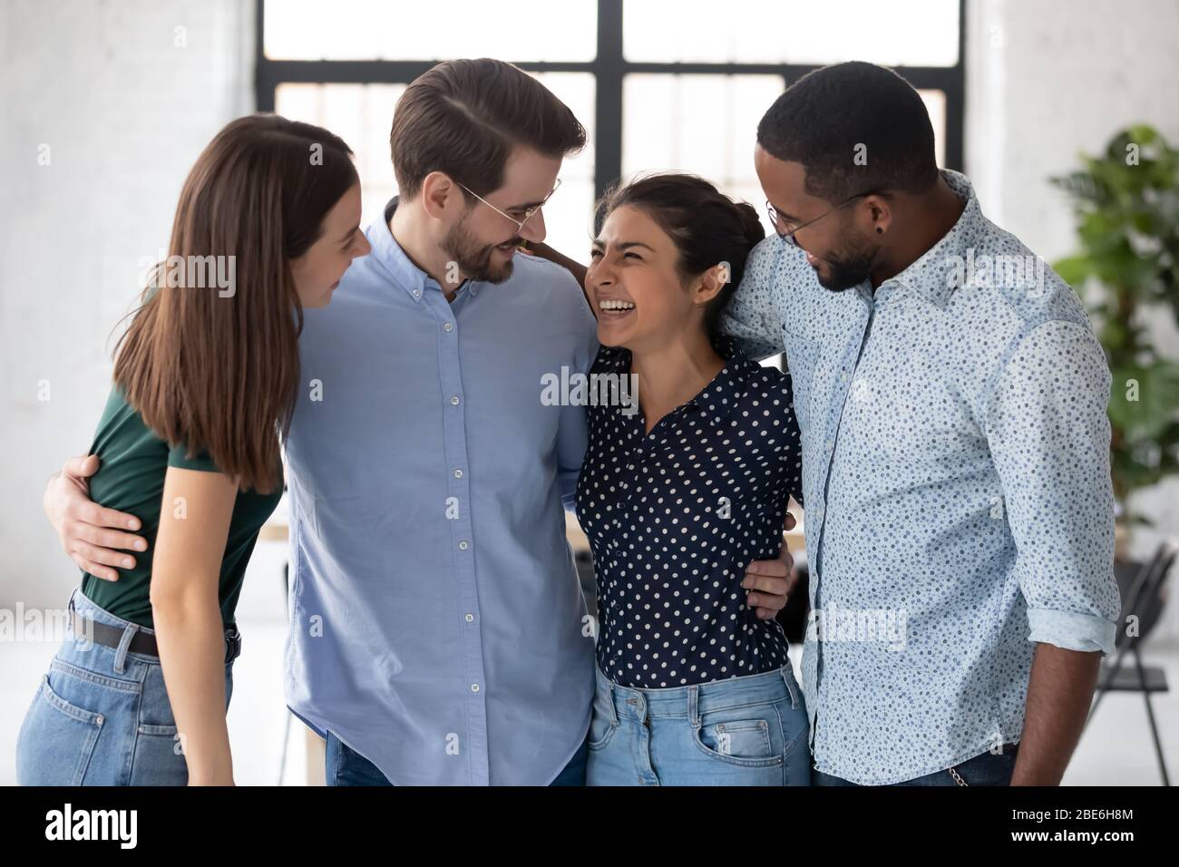 Glückliche multiethnische Kollegen zeigen am Arbeitsplatz Einheit Stockfoto