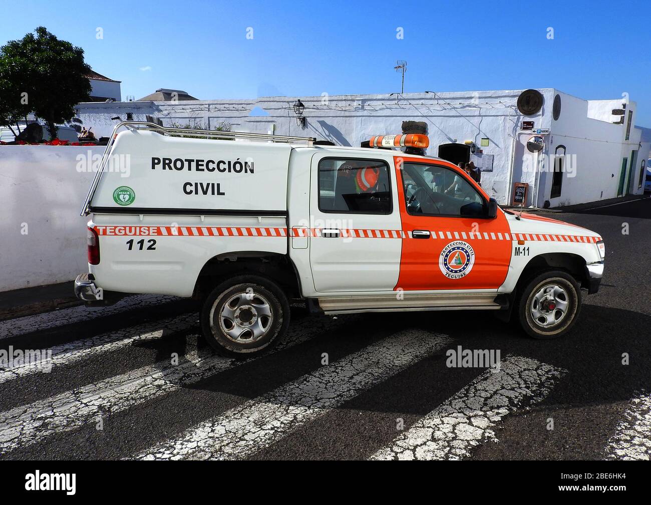 Teguise Zivilverteidigung TOYOTA Fahrzeug auf der Insel Lanzarote, kanarische Inseln, Spanien,- Januar 2020. Der Zivilschutz oder die Zivilverteidigung in Spanien begann am 12. August 1949 über das Protokoll 1 zusätzlich zum Genfer Vertrag, um sich mit dem "Schutz der Opfer internationaler bewaffneter Konflikte" zu beschäftigen und die Arbeit des Roten Kreuzes zu ergänzen. Heute sind sie in alles von Verkehrsmanagement und Rettung bis zu lokalen Katastrophen beteiligt. In diesem Fall blockierten sie Autos, die in Straßen in der Nähe eines regionalen Marktes parken. Die Farbe Orange wird auch von Rettungsfahrzeugen verwendet. Stockfoto