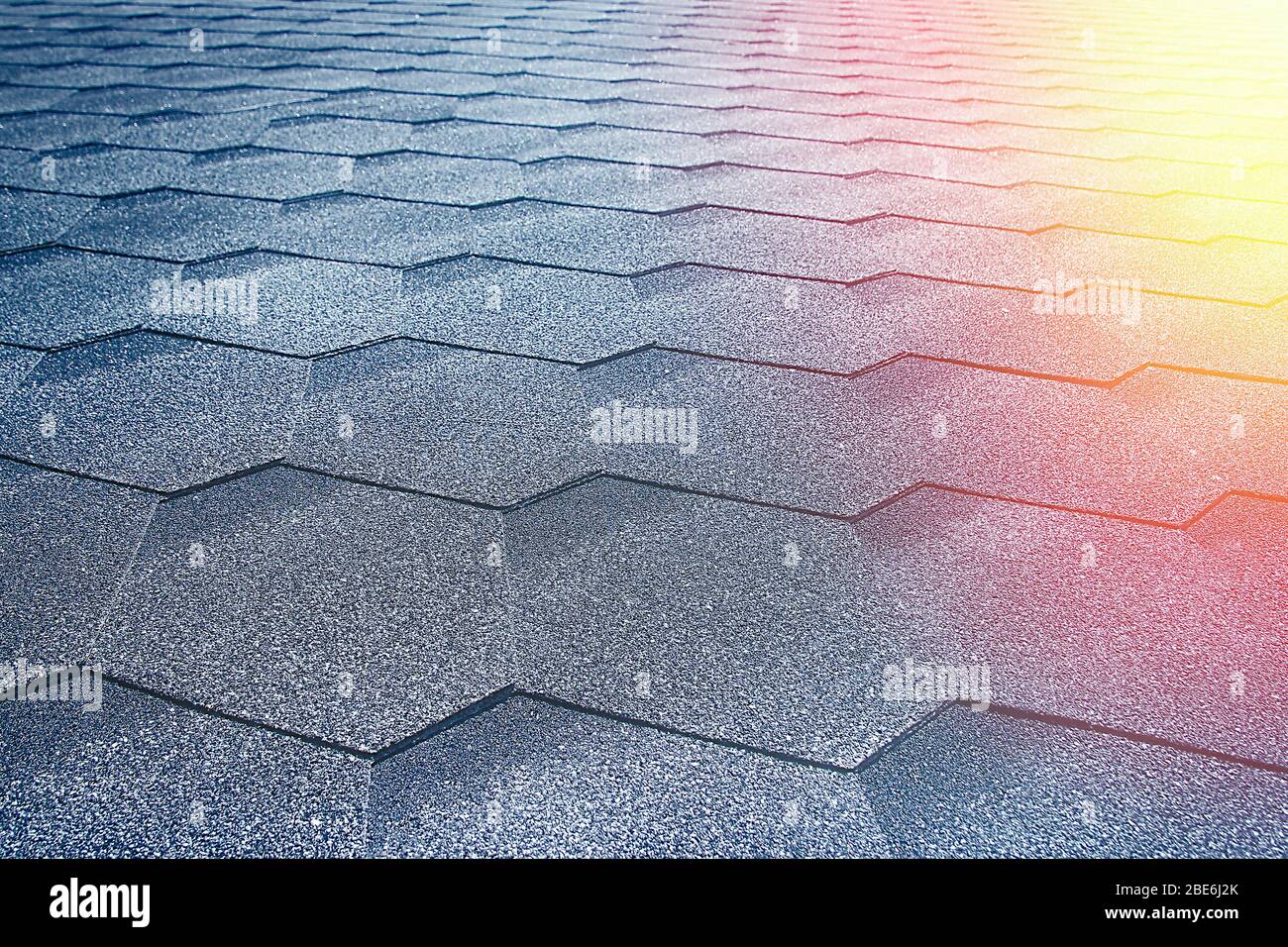 Graues weiches Dach auf dem Dach des Hauses. Nahaufnahme und Sonnenstrahl-Lichtecke Stockfoto