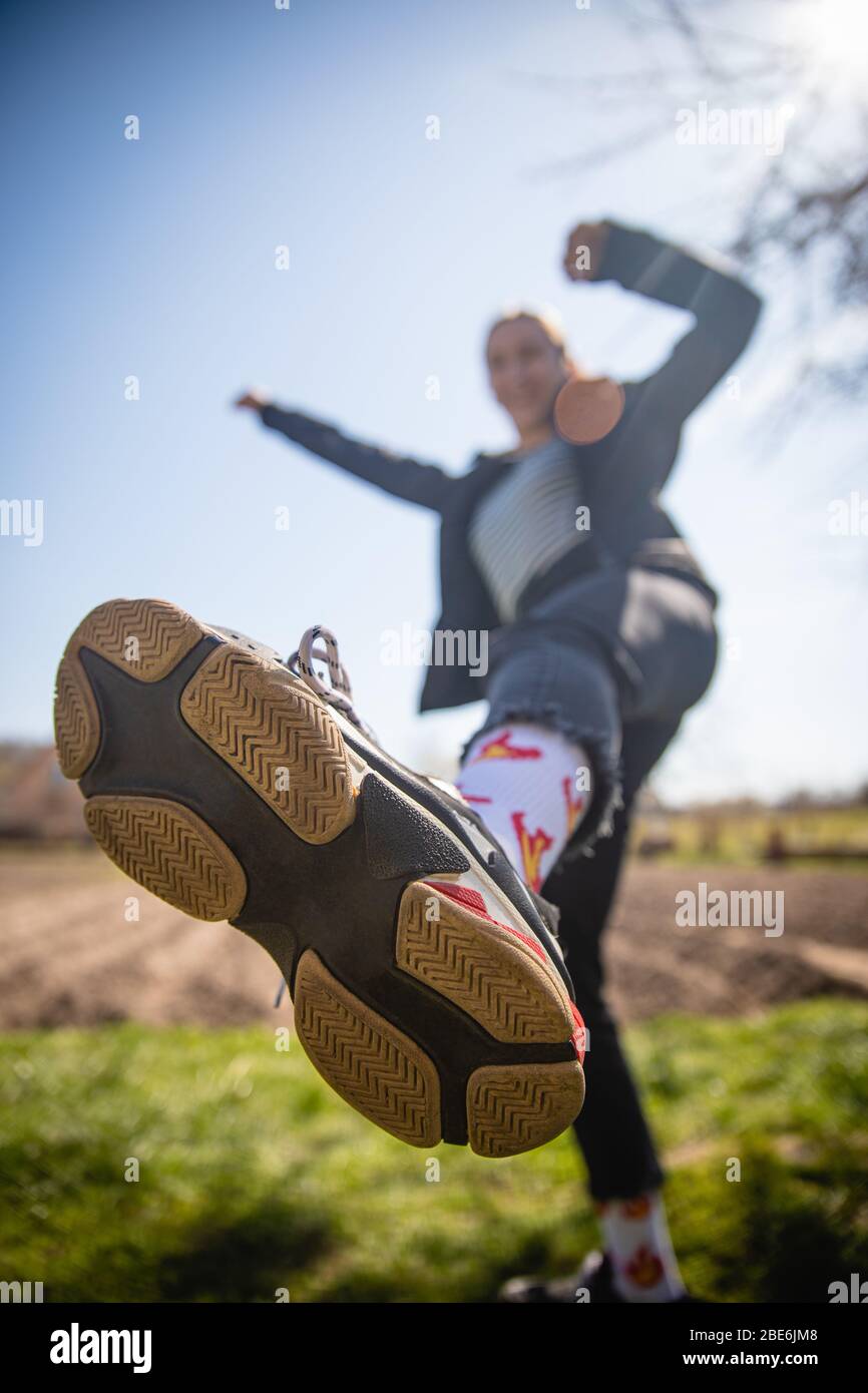 Sohle von Turnschuhen Closup von glücklichen Mädchen tanzen, springen und feiern Erfolg bewegen nach vorne in hellem Licht erreichen Stockfoto