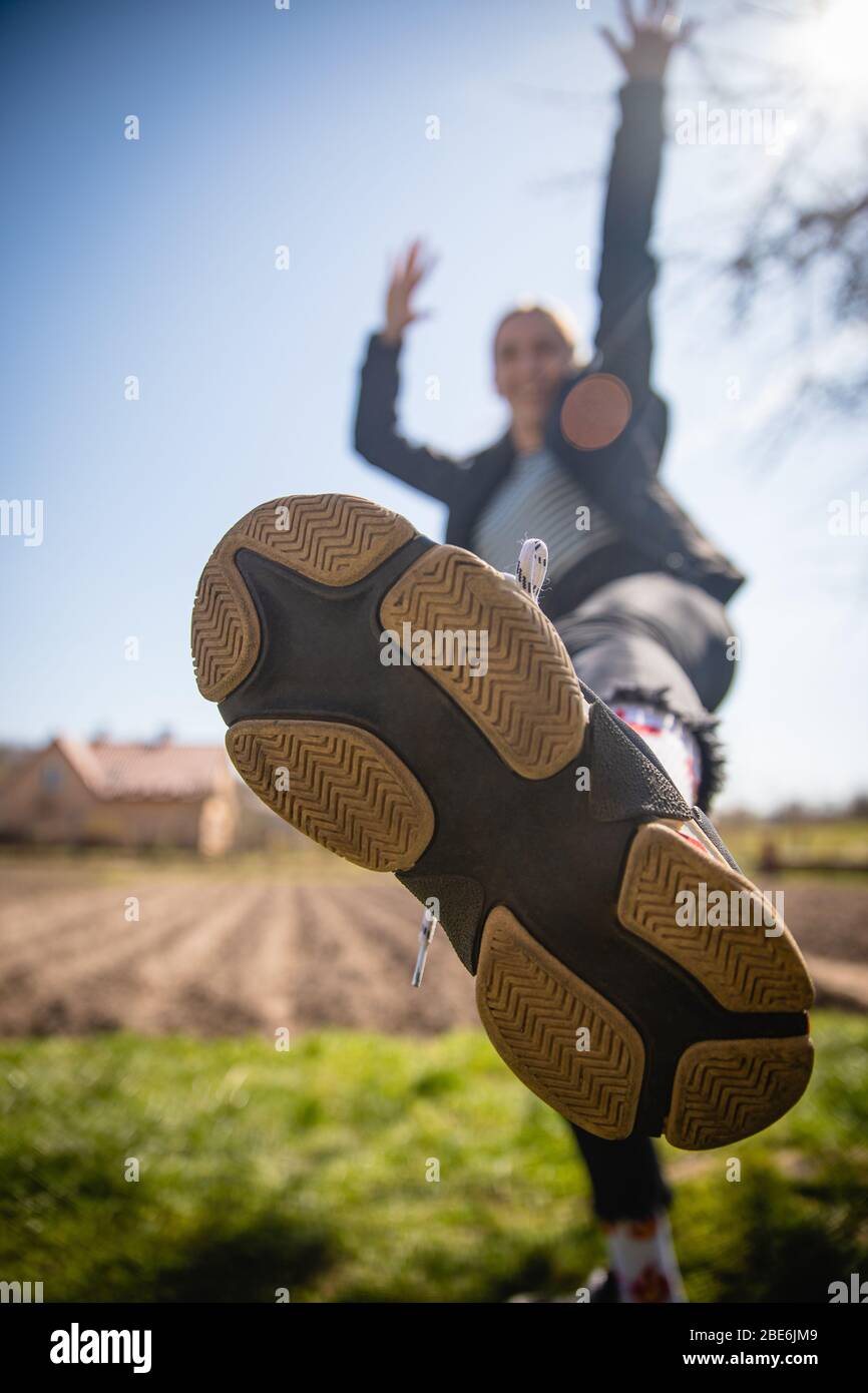 Sohle von Turnschuhen Closup von glücklichen Mädchen tanzen, springen und feiern Erfolg bewegen nach vorne in hellem Licht erreichen Stockfoto