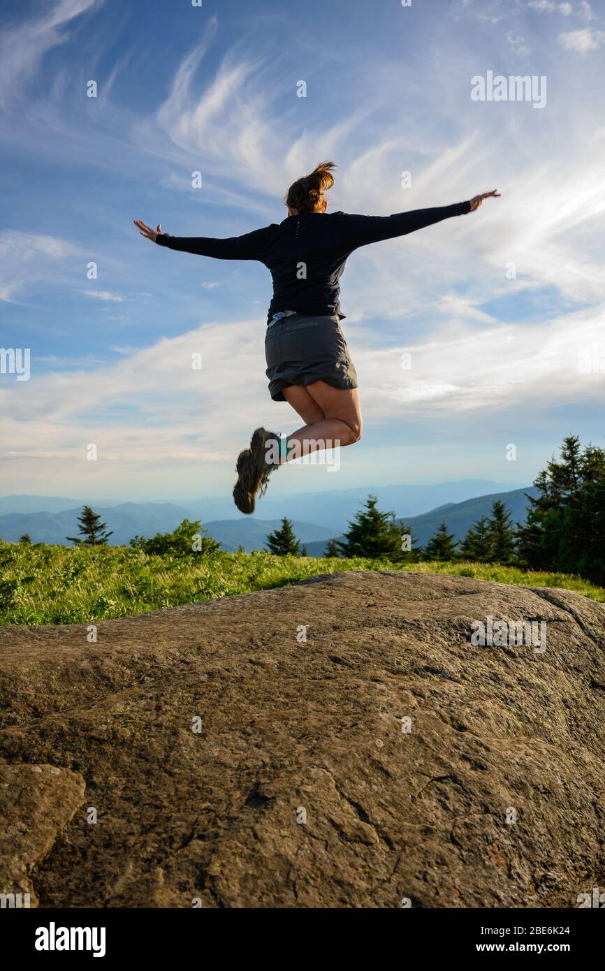 Springen vor Freude gegen einen Swirly Bewölkten Himmel in Blue Ridge Mountains Stockfoto