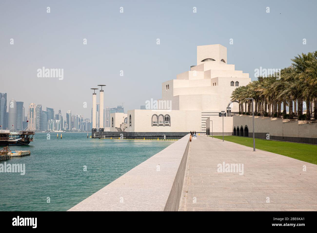 Blick auf das weiße Museum für Islamische Kunst in Doha City in Katar mit persischem Golf Wasser Hintergrund und rohen Palmen Stockfoto