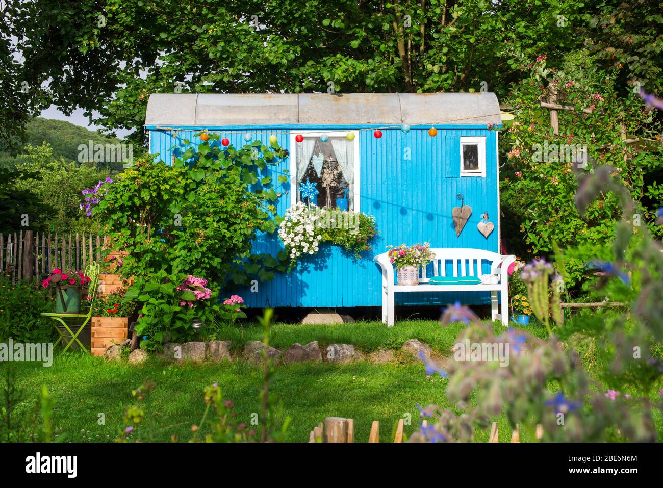 Alte Bauanhänger in einem verzauberten Garten Stockfoto