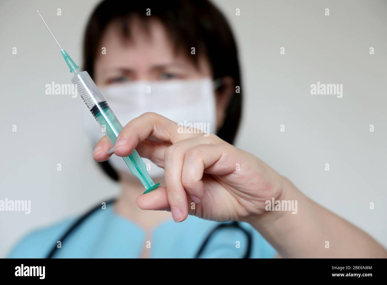Arzt mit Spritze, Frau in der medizinischen Maske Vorbereitung auf die Injektion. Konzept der Impfung, Behandlung der Coronavirus-Infektion Stockfoto