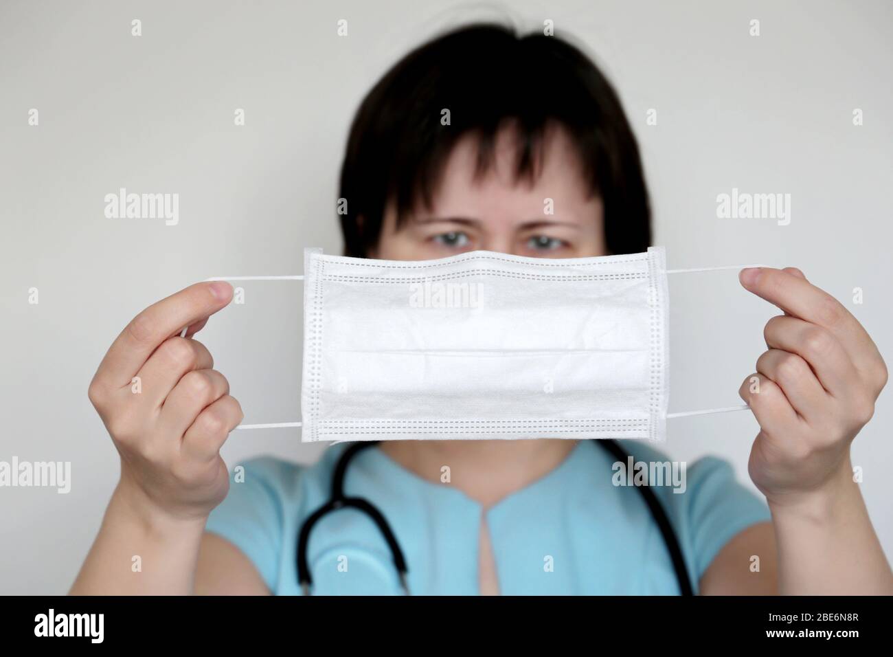 Coronavirus Schutz, Frau trägt medizinische Maske. Doktor mit weißer Grippemaske in den Händen, Konzept der Covid-19 Quarantäne Stockfoto