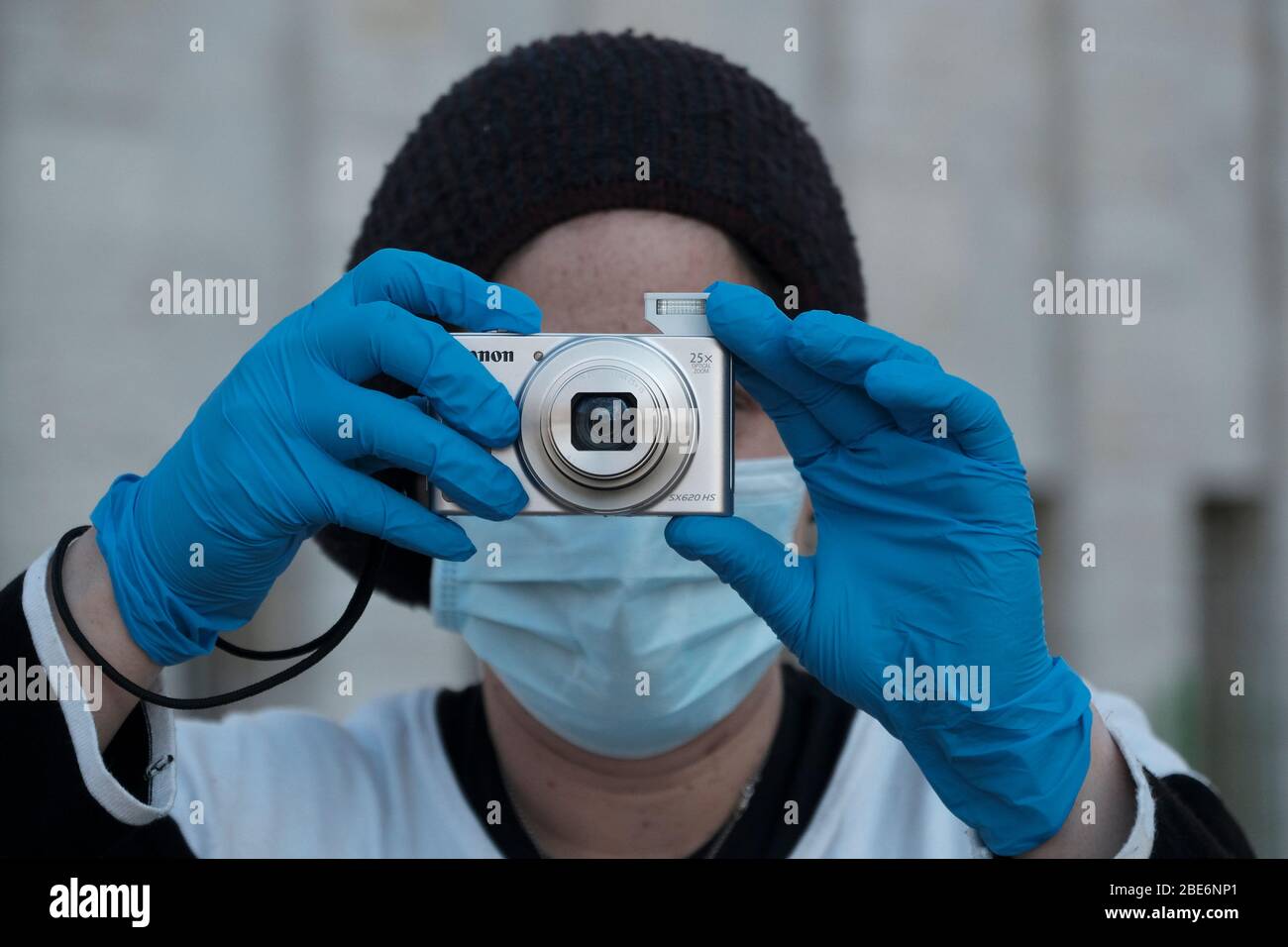 Eine ultra-orthodoxe Jüdin, die wegen der COVID-19-Coronavirus-Pandemie Schutzmaske und Latexhandschuhe trägt, fotografiert mit einer kleinen Taschenkamera in Mea Shearim, das als Ultra-orthodoxe Nachbarschaft in Jerusalem bezeichnet wird. Israel Stockfoto