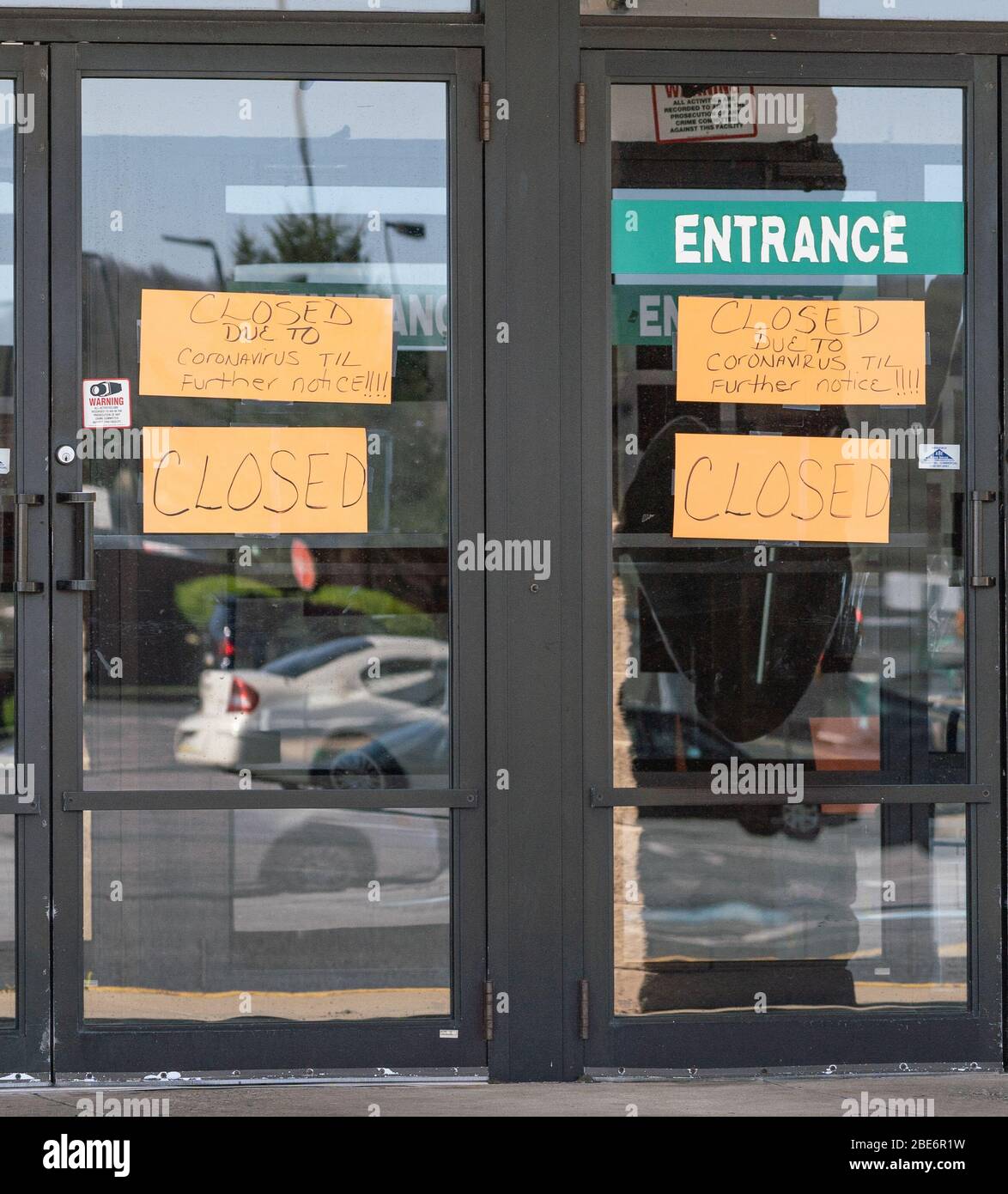 Schild an der Tür des Stores: „Geschlossen durch Coronavirus“. Stockfoto