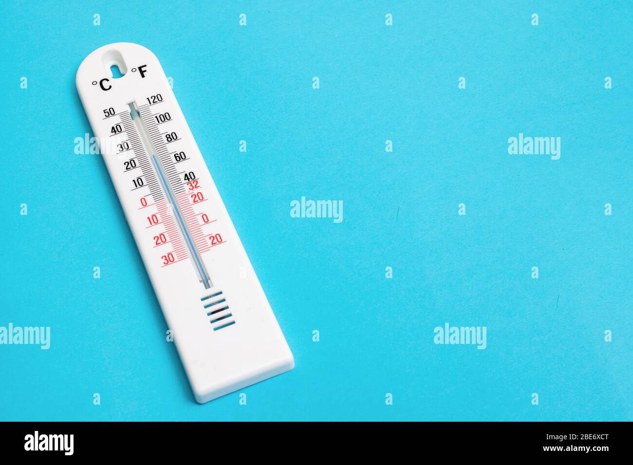 Weißes Zimmerthermometer auf blauem Hintergrund Stockfoto