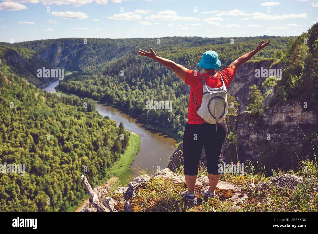 Die plump-Frau hob ihre Hände hoch und freute sich über den Aufstieg zum Berg. Das Konzept des Sieges über sich selbst, Motivation, Charakterstärke. A Stockfoto