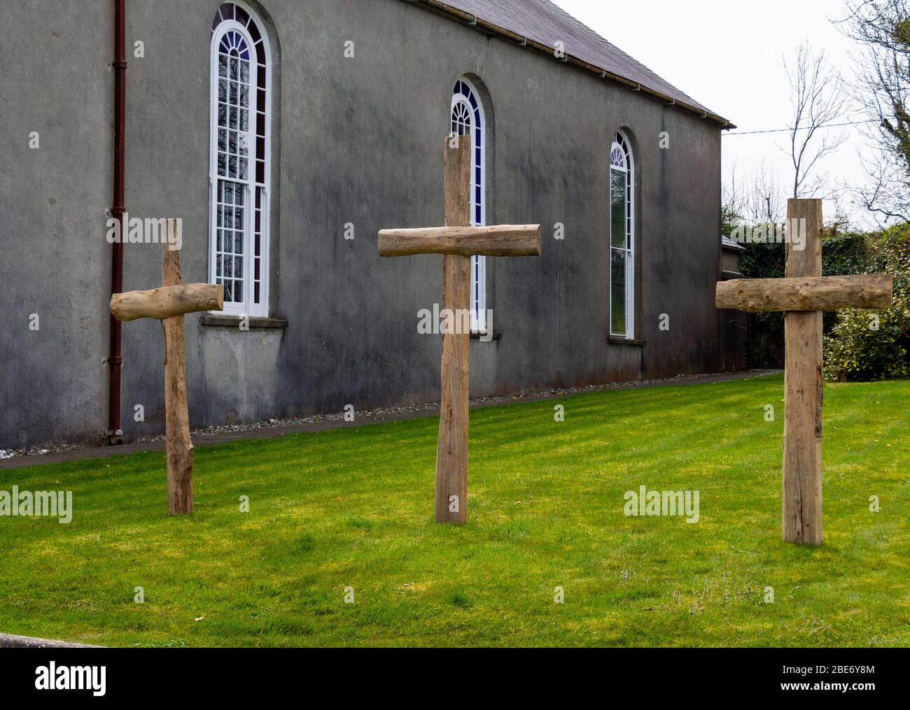3 Holzkreuze vor einer Irish Barn Church Stockfoto