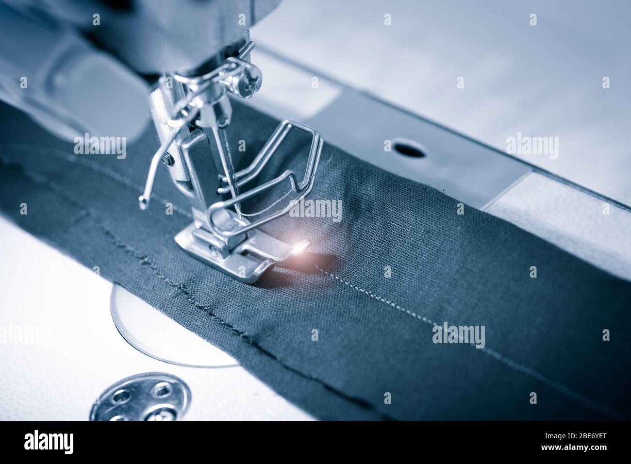 Nähmaschine Arbeitsteil mit Tuch. Technologie, Fertigung, handwerkliches Konzept. Stockfoto