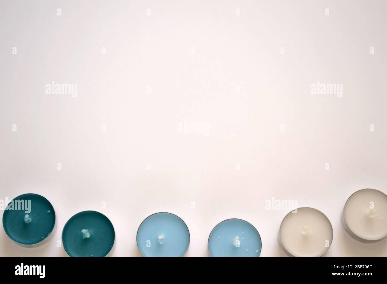 Runde blaue Kerzen lagen flach auf dem weißen Hintergrund Stockfoto