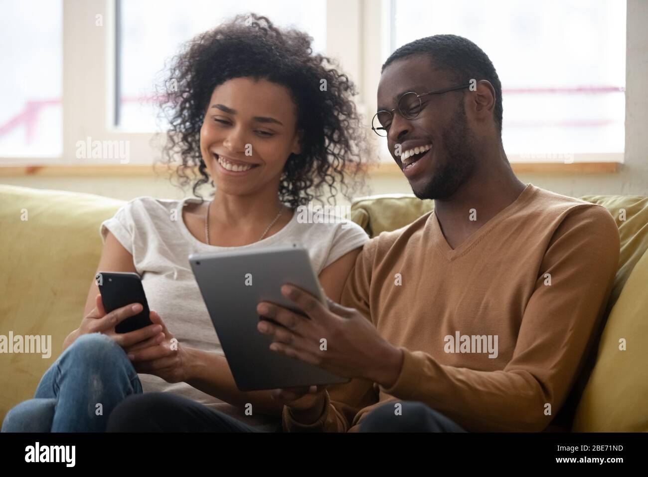 Lachende afroamerikanischen Mann und Frau paar Blick auf Smartphone Stockfoto