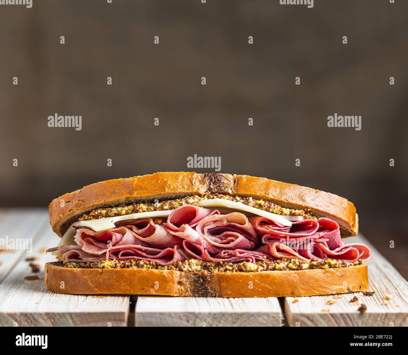 Schinken und schweizer Sandwich auf Holzfläche mit Leinenhintergrund Stockfoto