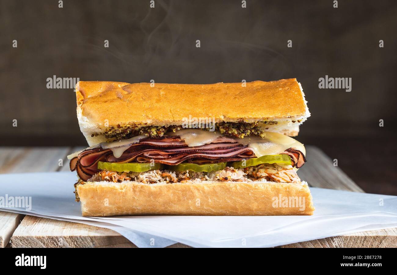 Heiß geschmolzener Schinken Gurken und Käse Sandwich mit Dampf auf Holzfläche Stockfoto