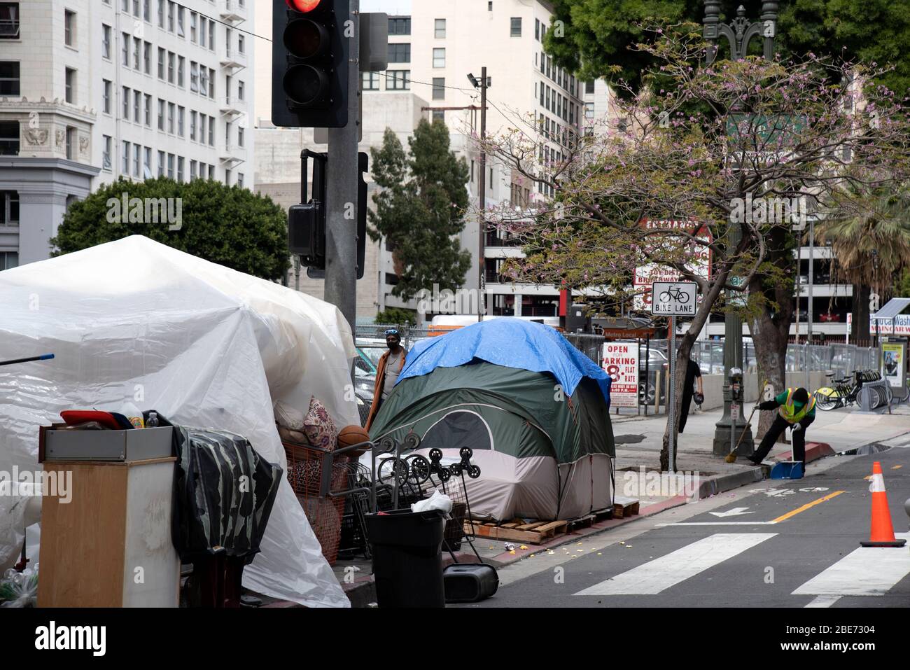 Los Angeles, CA/USA - 9. April 2020: Städtische Sanitäter versuchen, die Straßen um die Zelte der Obdachlosen während des COVID-19 Ausbruchs zu reinigen Stockfoto